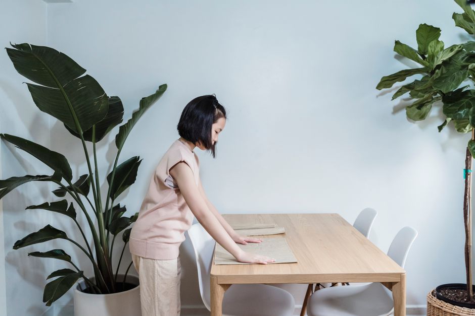 Photo by Annushka Ahuja on Pexels A young girl setting a dining table in a modern, plant-filled interior. - Photo by Annushka Ahuja on Pexels