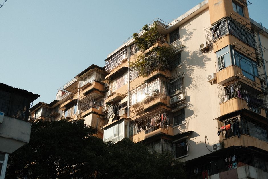 A multi-story urban building with balconies and air conditioning units under a clear sky. Photo by Muhamad Guruh Budi Hartono on Pexels