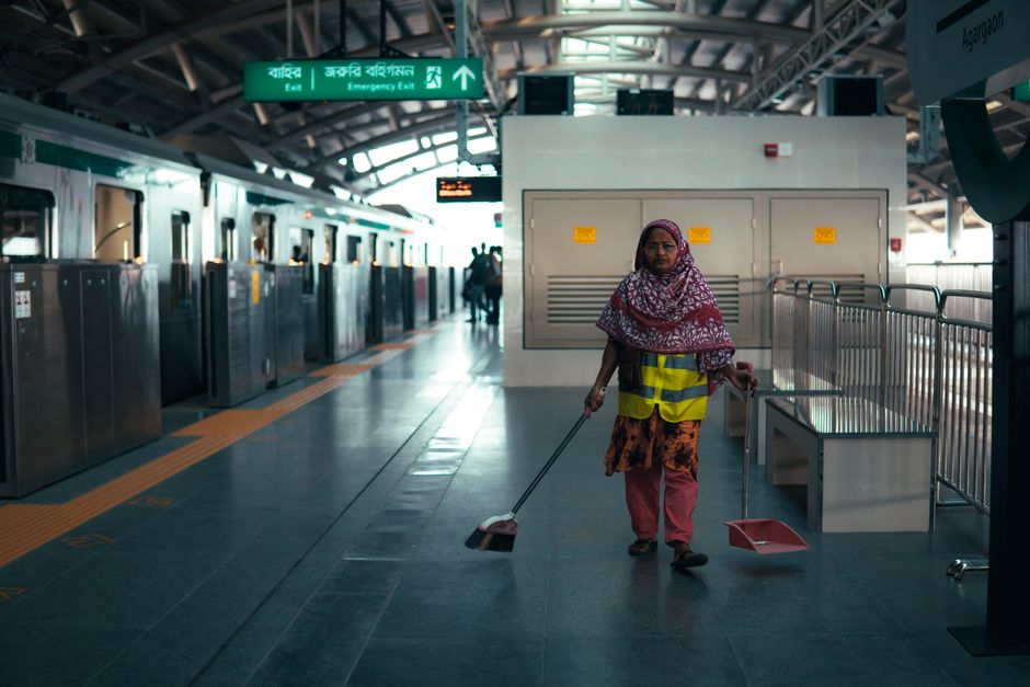 A worker cleans the platform at Dhaka metro station on a winter morning. Photo by Tafsin Naeem on Pexels