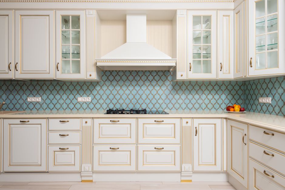 Interior of light modern kitchen with wooden white cabinets and blue tile backsplash with classic hood. Photo by Max Vakhtbovych on Pexels