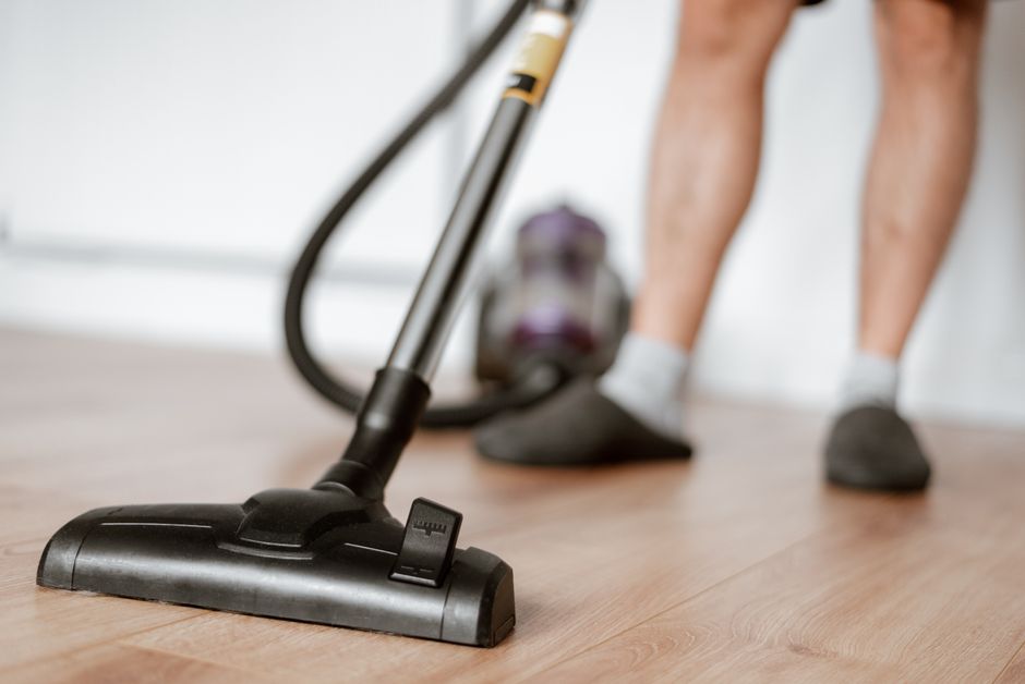 Crop anonymous male in slippers washing floor with vacuum cleaner in flat during household routine. Photo by Anete Lusina on Pexels