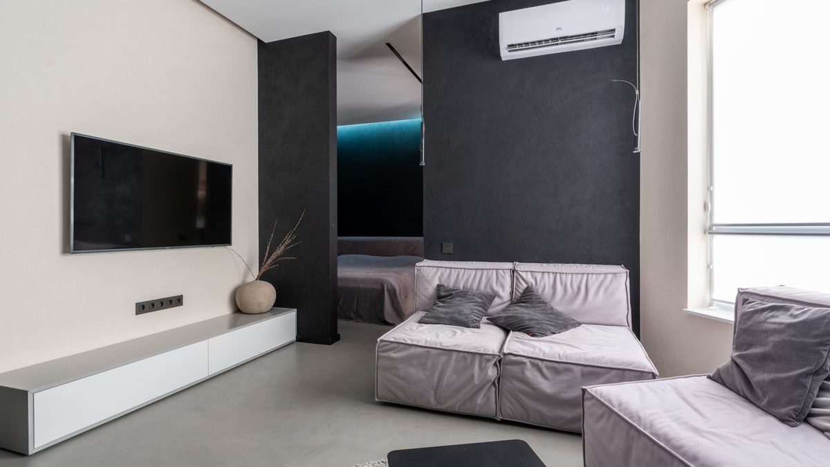Bright living room with wall-mounted air conditioner above a sofa. Photo by Max Vakhtbovych on Pexels