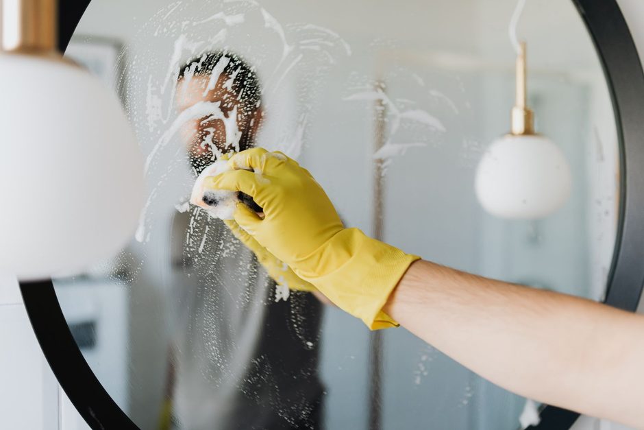 Photo by https://kaboompics.com/ on Pexels Hand in yellow glove wiping a round bathroom mirror. Photo by https://kaboompics.com/ on Pexels
