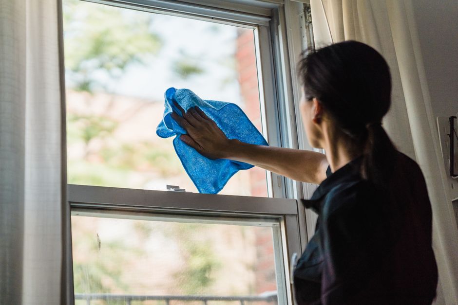 A woman cleans a window using a blue microfiber cloth providing a streak-free shine. - Photo by Liliana Drew on Pexels