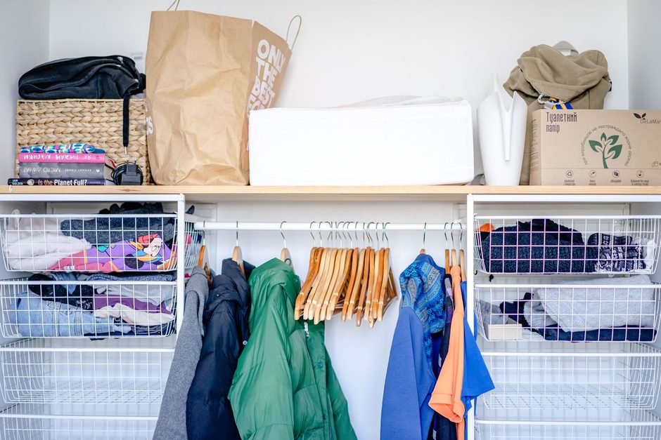 Organised wardrobe with hanging clothes and shelves in a clean home. Photo by Atlantic Ambience on Pexels