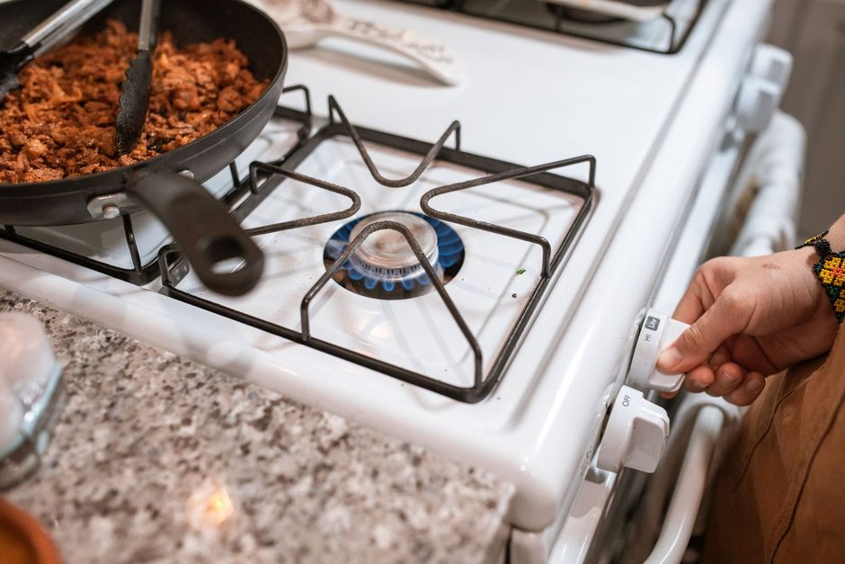 Gas stove hob with burners and a pan on a bright kitchen counter. Photo by RDNE Stock project on Pexels
