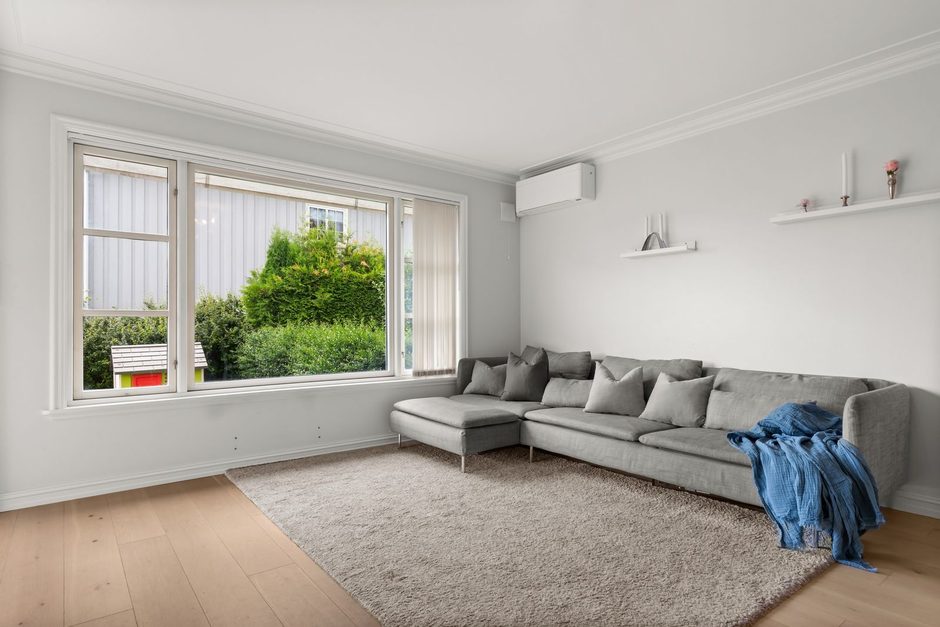 Bright modern living room with grey sofa and large window overlooking greenery. Photo by Alex Tyson on Pexels