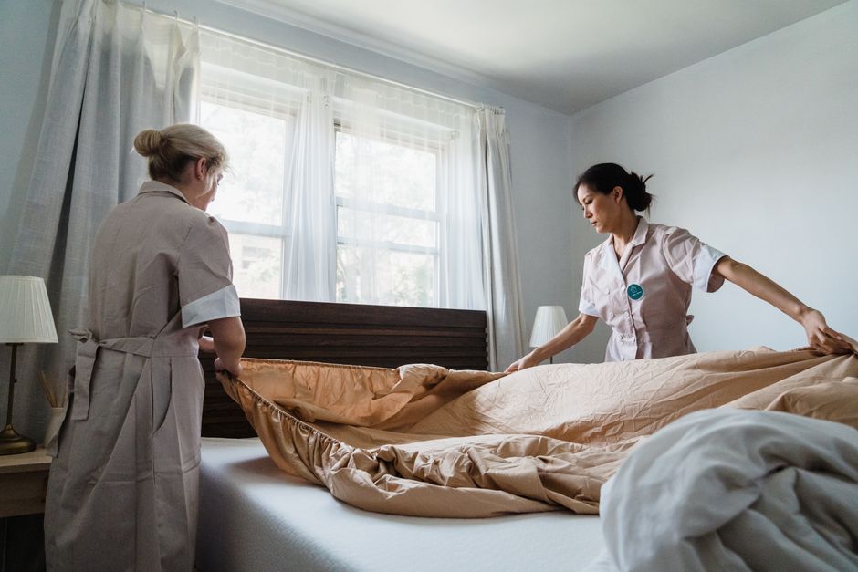 Photo by Liliana Drew on Pexels Two housekeepers professionally making a bed in a bright, comfortable room. - Photo by Liliana Drew on Pexels