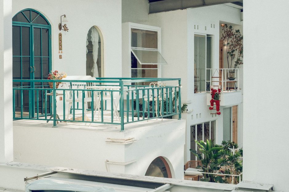 Photo by YI REN on Pexels Apartment building balcony with teal metal railing and outdoor tiled floor. Photo by YI REN on Pexels
