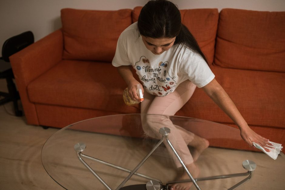 Photo by RDNE Stock project on Pexels Woman wiping a glass coffee table in a living room beside an orange sofa. Photo by RDNE Stock project on Pexels