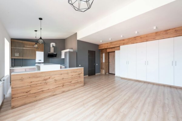 Spacious minimalist kitchen with wood accents and white cabinets.