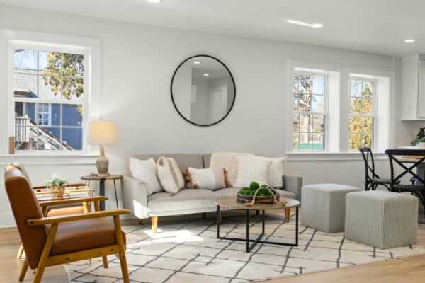 Bright Scandinavian-style living room with chic furniture and abundant natural light from large windows.