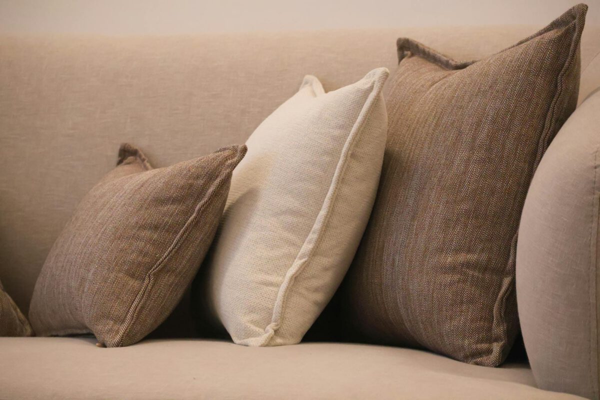 Comfortable sofa with neutral tones of brown and beige throw pillows for a warm living room setting.