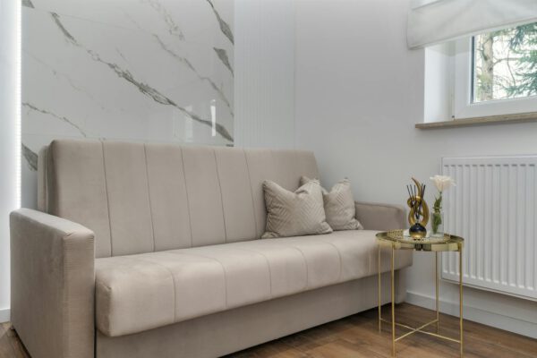 A stylish and minimalist living room featuring a neutral sofa and elegant decor.