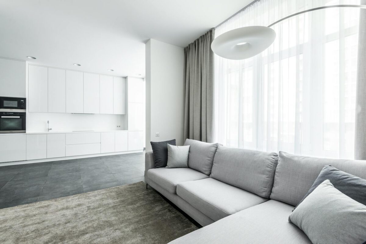 Bright modern living area featuring a cozy sofa and minimalist kitchen background.