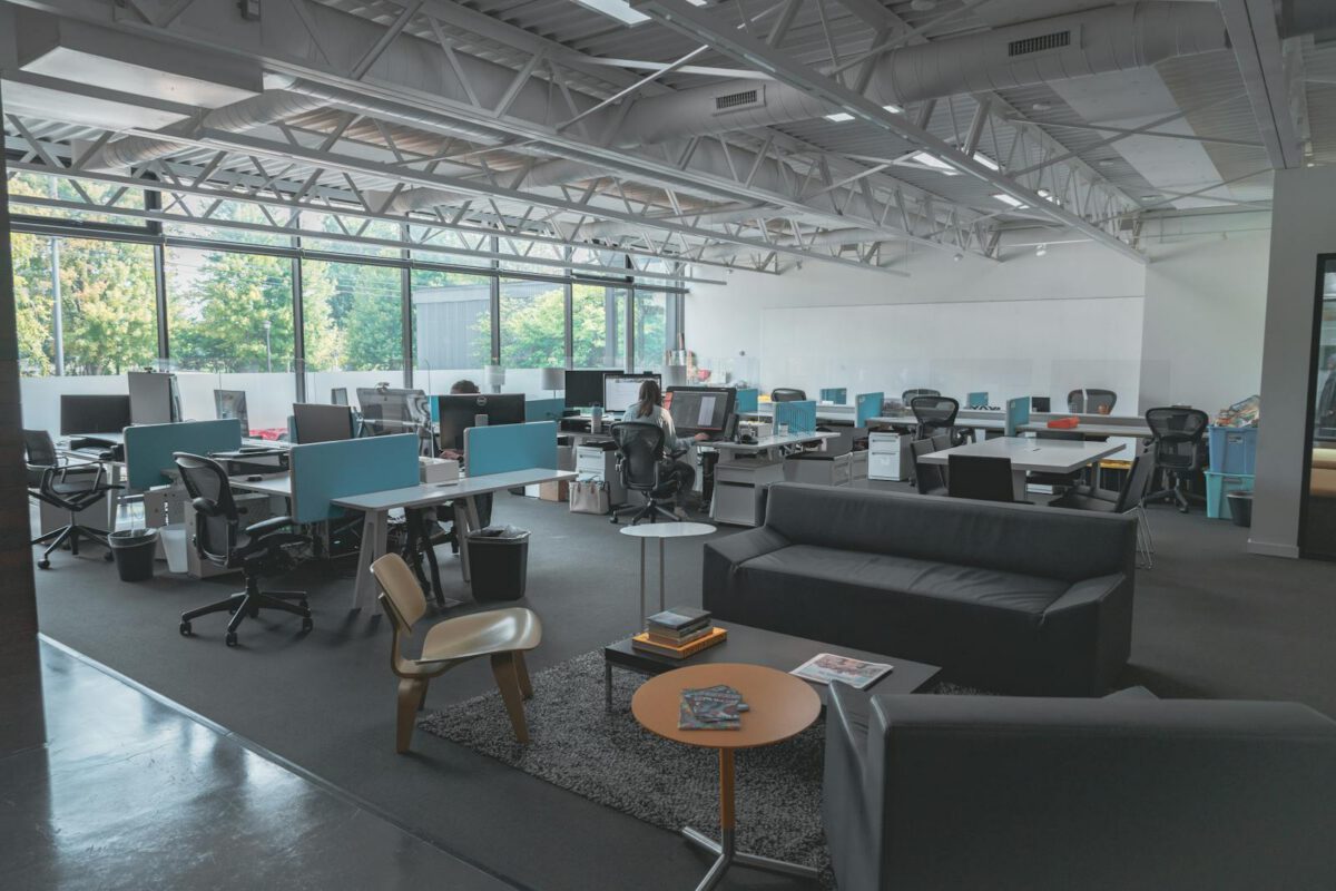 A spacious modern office with desks, computers, and natural light creating an inviting work environment.