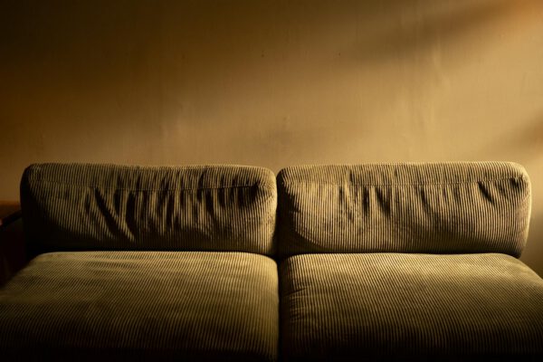 A plush corduroy sofa bathed in warm ambient lighting, perfect for cozy interiors.