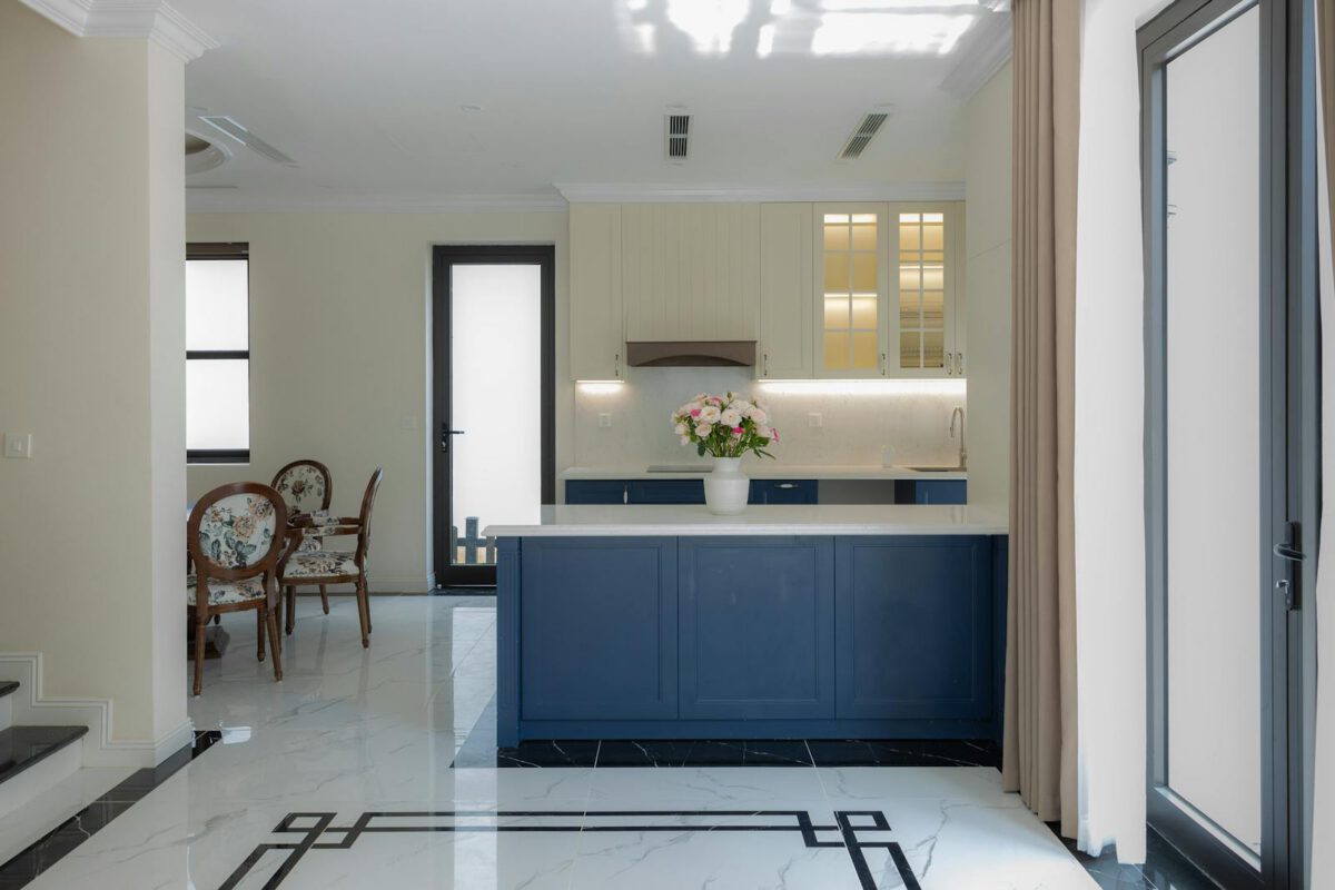 Bright and elegant modern kitchen featuring blue cabinetry and marble flooring.