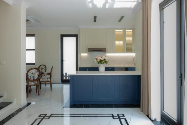 Bright and elegant modern kitchen featuring blue cabinetry and marble flooring.