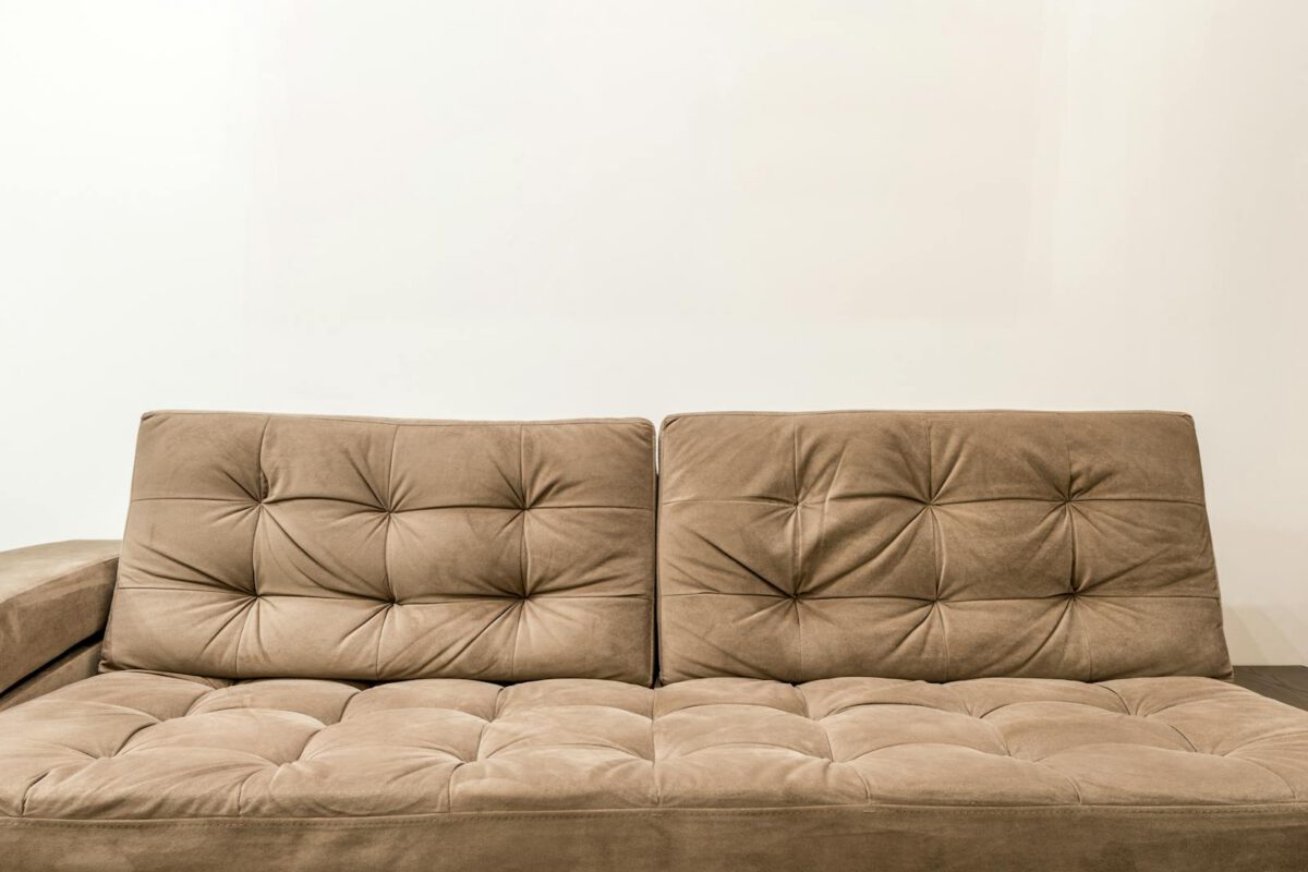 Comfortable brown couch with tufted design in contemporary living room setting.