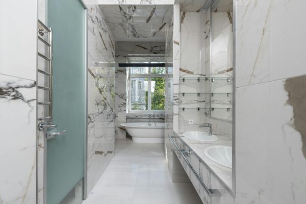 Modern marble bathroom featuring a stylish bathtub and double sinks, perfect for luxury home interiors.