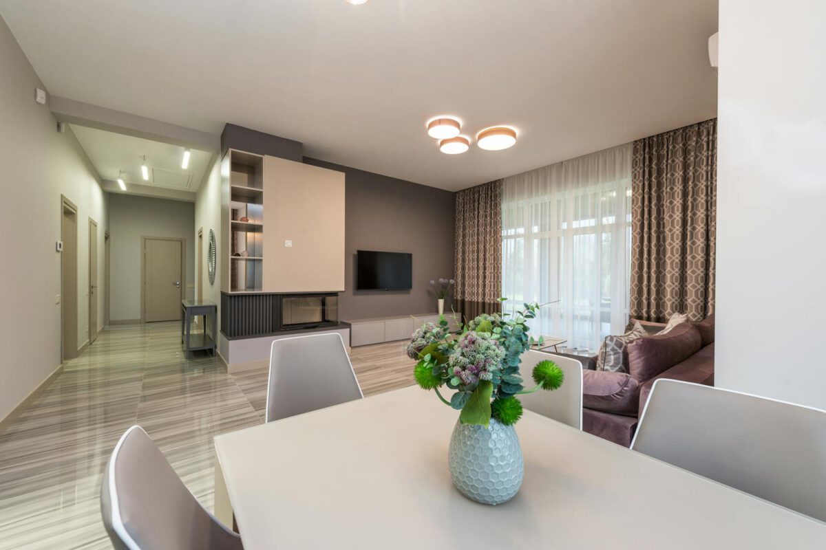 Large flat with modern interior with glowing lights on ceiling and curtains on window