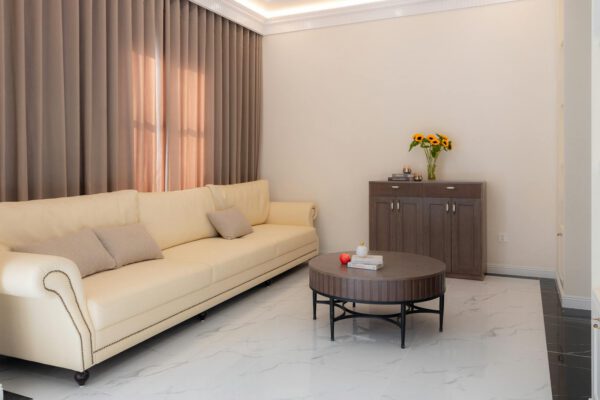 Stylish living room featuring a beige sofa, sunflowers, and chic decor.