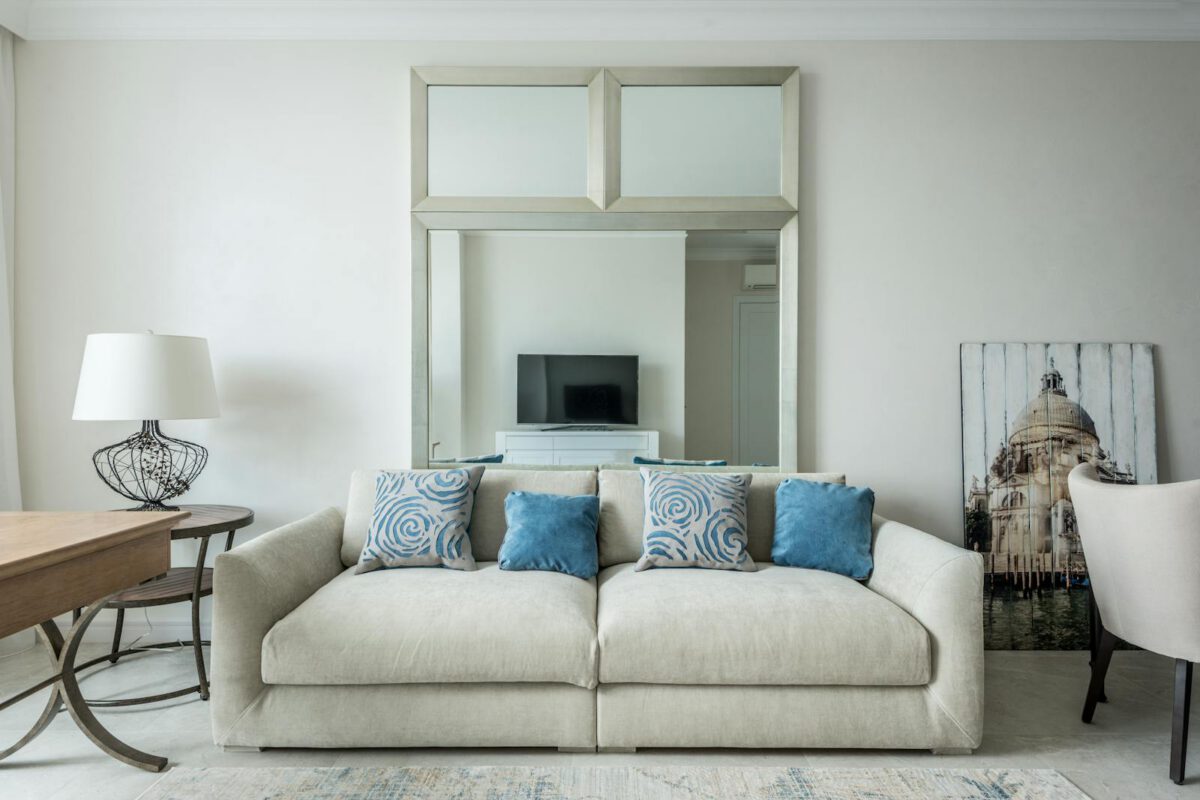 Comfortable couch with soft pillows located in cozy living room with furniture and carpet