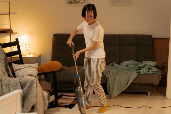 Asian woman vacuuming a living room at home