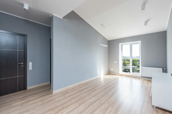 Bright minimalist room with wooden flooring and large window