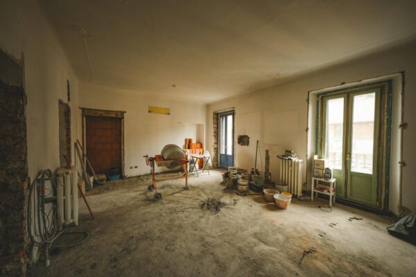 Wide view of a sunny room under renovation with construction materials