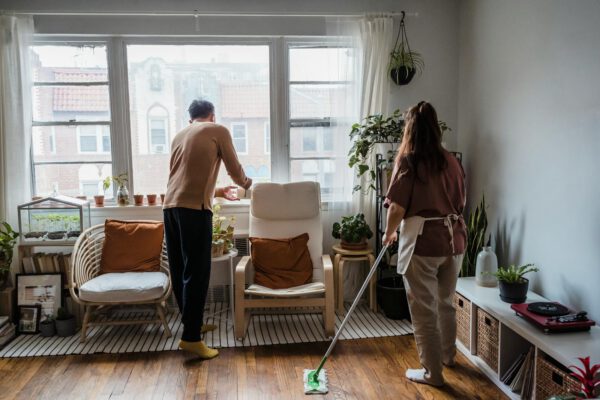 Asian couple tidying up a bright plant-filled living room