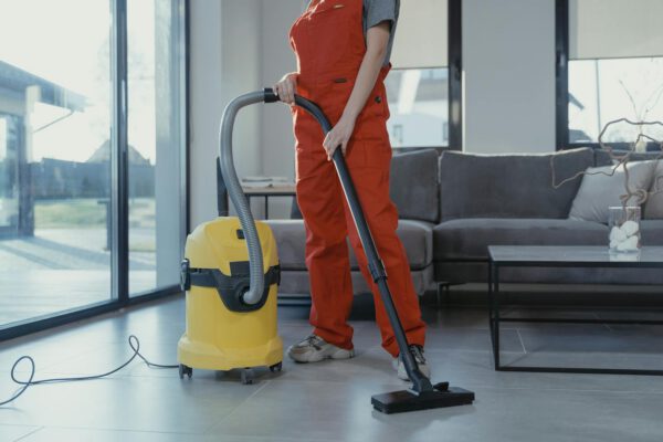 Professional cleaner vacuuming a modern living room