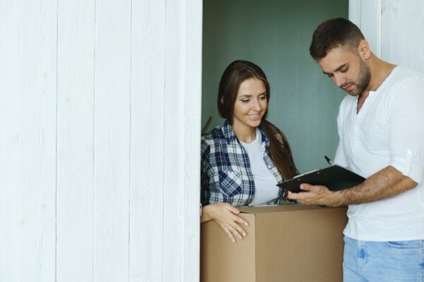Young couple signing a document while moving into their new home.