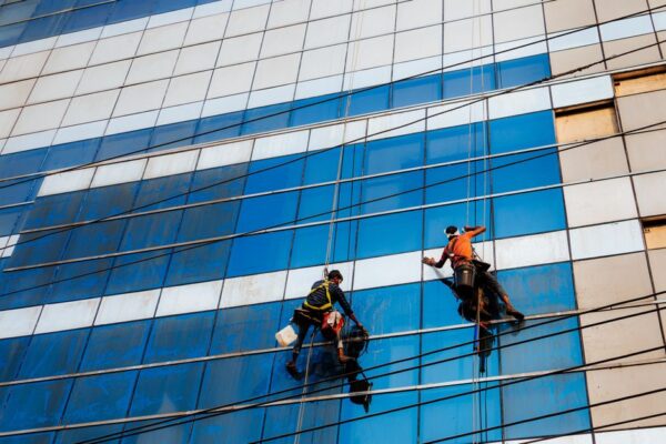 Two window cleaners working on a skyscraper facade in Dhaka, Bangladesh.